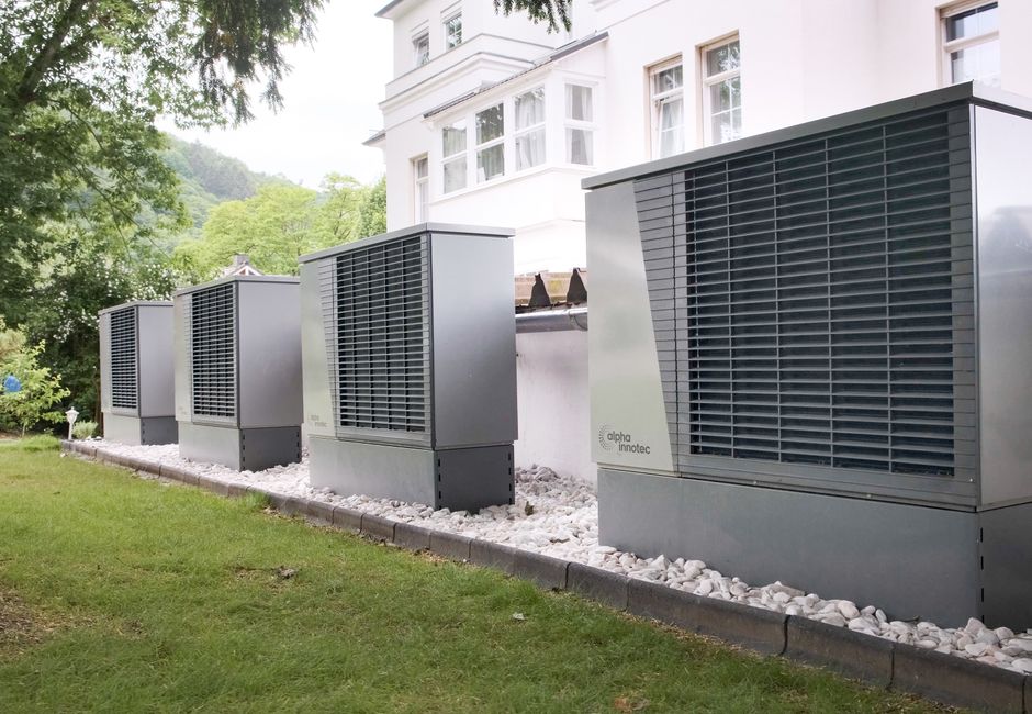 Rangée de pompes à chaleur air/air installées le long d'une maison, côté jardin